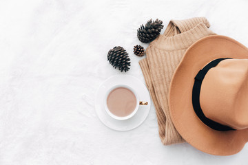 flat lay with feminine accessories: sweater, hat. Hot coffee. Cozy home autumn. Top view, copy space