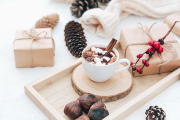 Hot chocolate in cup with wrapped gift . Holiday christmas concept. Cozy home background