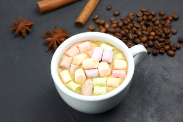 coffee drink with marshmallows and spices. on a dark background. view from above. copy space. morning refreshing drink.