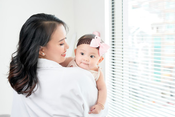 happy loving family. mother playing with her baby in the bedroom.