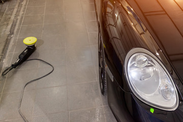 Maintenance of a black luxury car in operation after washing and coating with special wax using a...