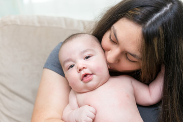 mother is kissing her cute infant son
