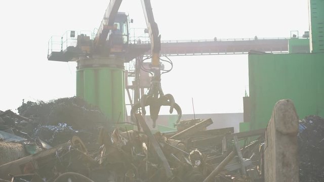 yellow hydraulic Clow Crane used for picking up scrap metal at recycling yard