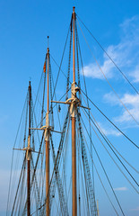 Group of three masts from the same ship with different wood colors