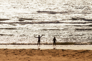 Fototapeta na wymiar Happy children playing at the beach at sunset