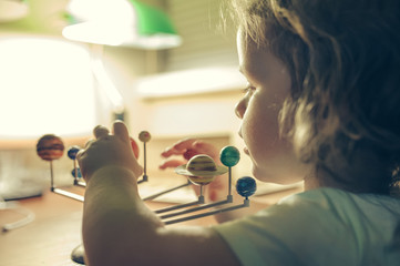  little girl looks at a model of the solar system © Kiryakova Anna
