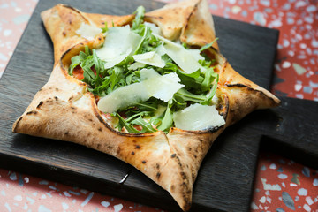 Star-shaped pizza with arugula and parmesan cheese