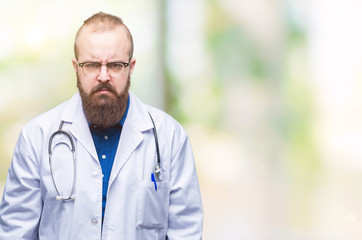 Young caucasian doctor man wearing medical white coat over isolated background skeptic and nervous, frowning upset because of problem. Negative person.