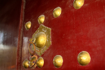 copper door knocker on the red door plank, China