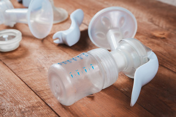 manual breast pump and parts on wooden table. closeup