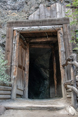 Fototapeta premium Historical door to bombshelter (anti-aircraft cover) in rock. Abandoned Mine entrance in rock.