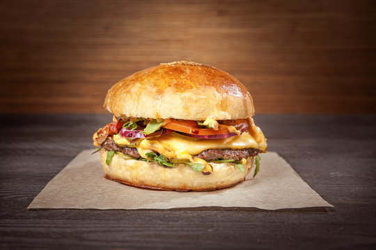hamburger with craft paper on wooden background. free space for logo. close-up