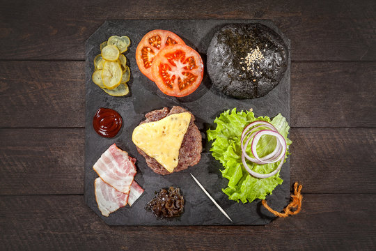 Ingredients for a hamburger on a slate board.top view
