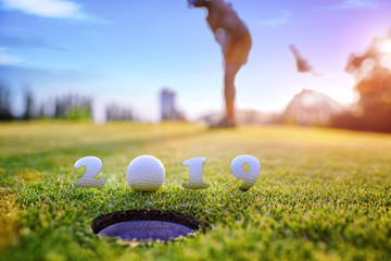 incoming year 2019, prepare by putting of woman golfer on the green,  golfball mostly ready to drop into the hole of new year success, Happy new year and merry Christmas on golf course