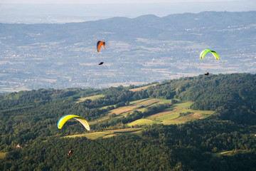 Paragliding at stunning mountain scenery with green pastures and forests