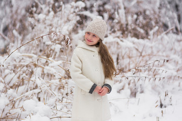 Portrait of a cute smiling girl on a snowy day in the forest