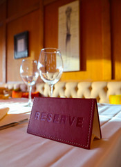 Reservation sign card in the luxury restaurant. Reserved table in at the cafe.