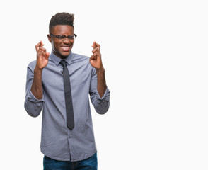 Young african american business man over isolated background smiling crossing fingers with hope and eyes closed. Luck and superstitious concept.