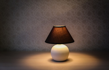 Table lamp with brown shade on a wooden table