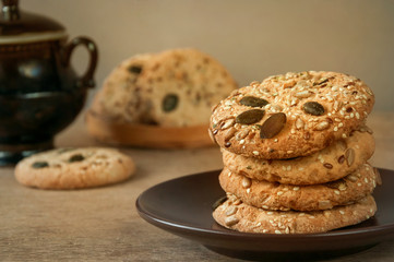 Homemade cookies with pumpkin and sunflower seeds on a wooden table.
