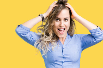 Fototapeta premium Beautiful young blonde business woman over isolated background Crazy and scared with hands on head, afraid and surprised of shock with open mouth