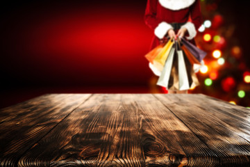 Wooden table of free space for your decoration and blurred background of christmas tree and people 