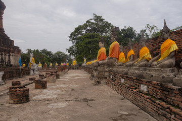 Fototapeta na wymiar Old Ancient Temple. Rows of Buddha Images around the central stupa at the Wat Yai Chai Mongkol temple in Ayutthaya, Thailand.