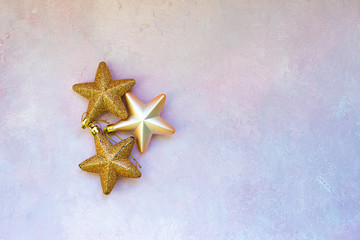 Christmas composition. Christmas stars, golden decorations on light pink background. Flat lay, top view, copy space