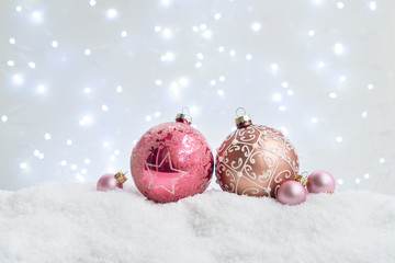 White christmas with snow - pink balls with festive lights in background