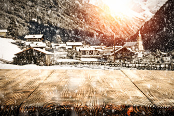 Table background of wooden table and Alps landscape with snow and sun light 