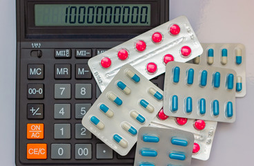 Drugs in the form of tablets lie next to the calculator. on the calculator figure million