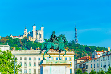 Basilica Notre-Dame de Fourviere viewed behind statue of Louis XIV in Lyon, France