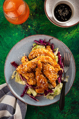 Salad with warm glazing chicken, sprinkled with sesame seeds. Chinese cuisine. Asian culture