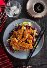 Salad with warm glazing chicken, sprinkled with sesame seeds. Chinese cuisine. Asian culture