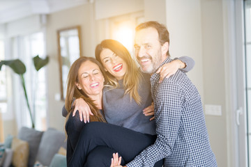 Beautiful family together. Mother, father and daughter smiling and hugging with love at home.