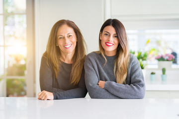 Beautiful family of mother and daughter together at home with a happy and cool smile on face. Lucky...