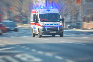 Paramedic 911 ambulance car running fast through the big city. - obrazy, fototapety, plakaty