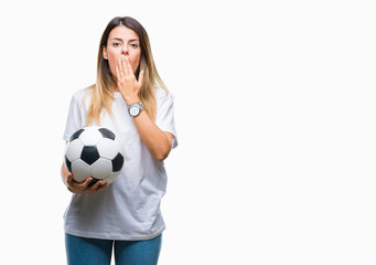 Young beautiful woman holding soccer ball over isolated background cover mouth with hand shocked with shame for mistake, expression of fear, scared in silence, secret concept