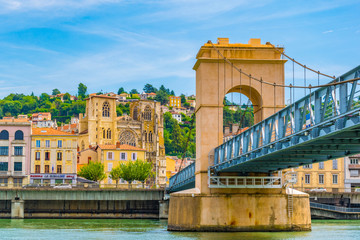 Cathedral in Vienne viewed behind a pedestrian bridge over river Rhone, France - obrazy, fototapety, plakaty