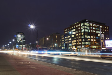 Obraz premium A modern office building and a night traffic in Poznan.