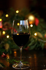 red wine in a glass on the background of garlands, Christmas trees and decorations. Christmas