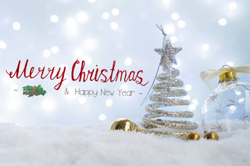 White christmas - christmas tree in snow with bokeh lights in background with Merry Christmas...