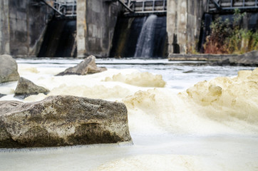 Foam on the surface of the water as a result of the discharge of water from the dam