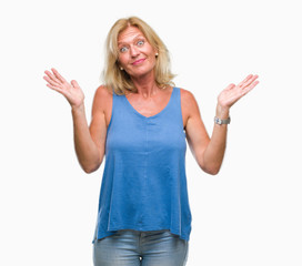 Fototapeta premium Middle age blonde woman over isolated background clueless and confused expression with arms and hands raised. Doubt concept.