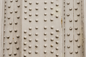 metal background with many rivets vertical panel weathering corrosion industrial design base silver