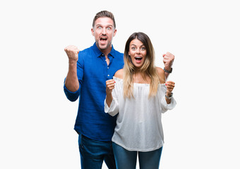 Young couple in love over isolated background celebrating surprised and amazed for success with...