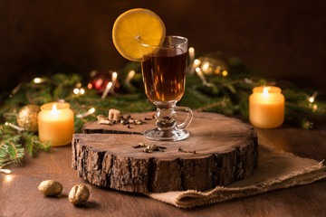 Cup of tea with oragne  and golden candle light near Christmas tree. Spirit of Christmas