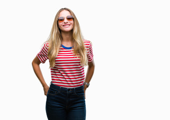 Obraz na płótnie Canvas Young beautiful blonde woman wearing sunglasses over isolated background with a happy and cool smile on face. Lucky person.