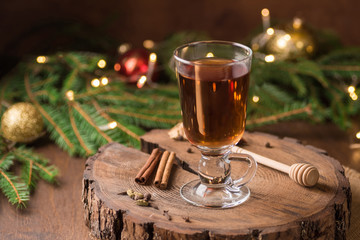 Spiced Apple Cider Mulled Sangria in glass cup on wooden background. Hot drinks for Christmas.
