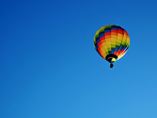 Colourful hot air balloon in a clear blue sky with copy space